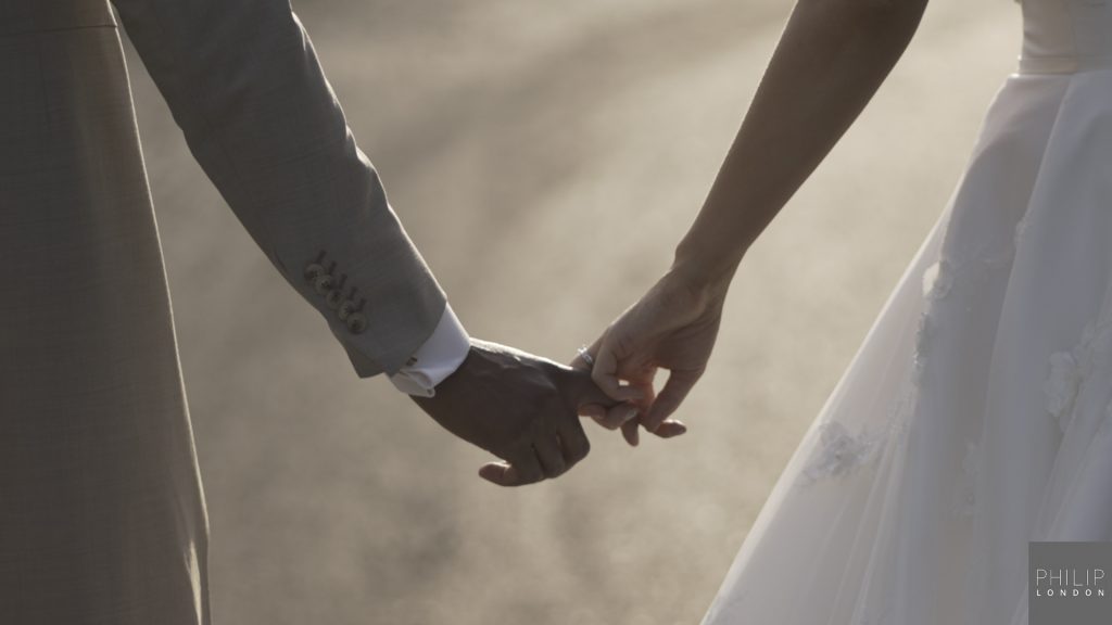 Couple holding hands on their wedding day.