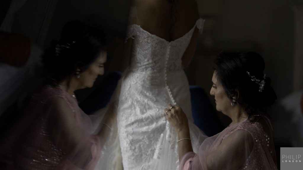 Mum getting daughter into her wedding dress